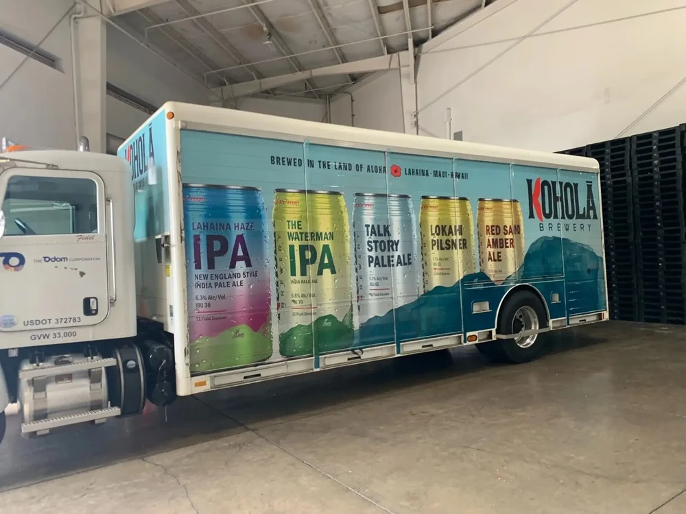 Развозной автомобиль Kohola Brewery с изображением банок напитка и горного пейзажа